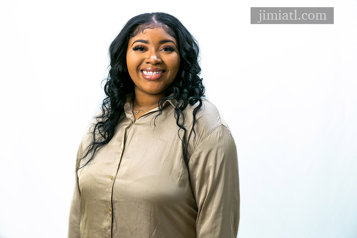 Woman poses for headshot photography in studio.